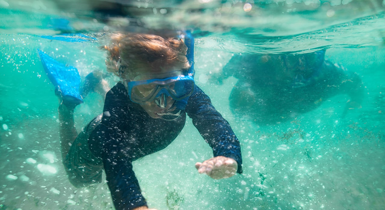 Harborwalk Village Watersports kids snorkeling in the water at regatta bay